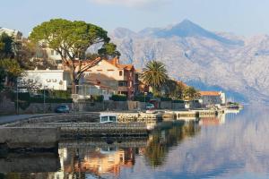a body of water with houses and a mountain at Fortress View apartment in Kotor