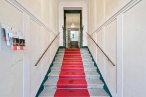 a red carpeted staircase in a building with a hallway at Imperial Apartments Schönbrunn - Contactless Check-In in Vienna