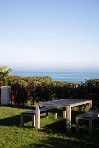 a picnic table with the ocean in the background at Villa Anvers Guethary in Bidart