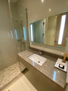 baño con lavabo y espejo grande en Aram Hotel - AlMeshael Exit 18, en Riad