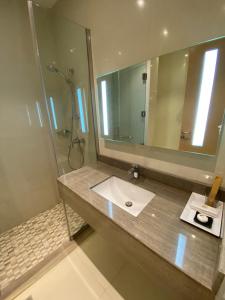 a bathroom with a sink and a large mirror at Aram Hotel - AlMeshael Exit 18 in Riyadh