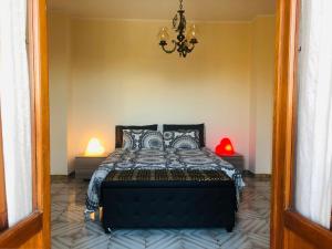 - une chambre avec un lit et un lustre dans l'établissement Residenza Donna Maria, à Ercolano