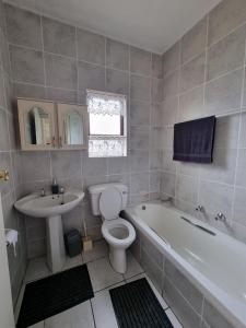 a bathroom with a tub and a toilet and a sink at Crows nest in Margate