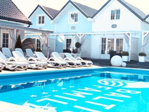 a swimming pool with chairs and a house at Domki BALTIC FAMILY basen kidsclub rowery in Mielno