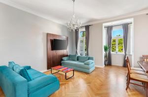 ein Wohnzimmer mit einem blauen Sofa und Stühlen in der Unterkunft Imperial Apartments Schönbrunn - Contactless Check-In in Wien