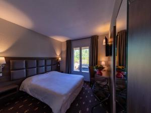 a hotel room with a bed and a window at Logis Noemys Morgon in Villié-Morgon