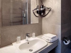 a bathroom with a sink and a phone on the wall at Logis Hotel Noemys Morgon in Villié-Morgon +45 photos