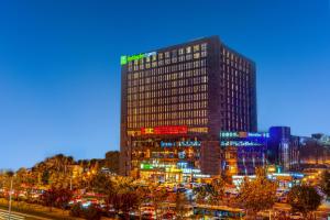 un edificio alto en una ciudad por la noche en Holiday Inn Express Beijing Huacai, an IHG Hotel, en Beijing