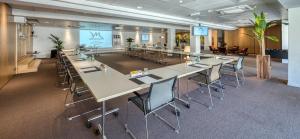 une salle de conférence avec des tables et des chaises dans un bureau dans l'établissement Mercure Pont d’Avignon Centre, à Avignon