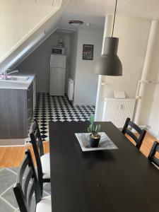 a dining room with a black table and chairs at Centrum lejlighed in Viborg