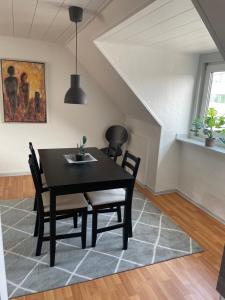 a dining room with a black table and chairs at Centrum lejlighed in Viborg