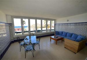 een woonkamer met een blauwe bank en een tafel en stoelen bij The Beach House at Playa Salobreña in Salobreña