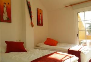 um quarto com 2 camas com almofadas vermelhas e uma janela em The Beach House at Playa Salobreña em Salobreña