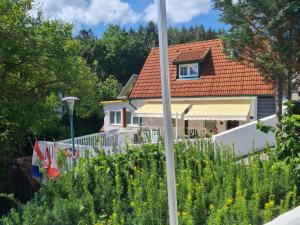 uma casa com um telhado vermelho num jardim em Ferienhaus BLACK & WHITE em Bromberg