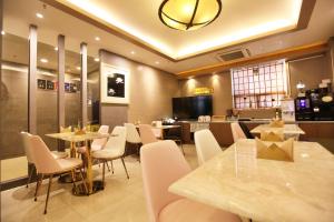 昌原市Changwon AT Business Hotel的一间有桌椅和厨房的餐厅