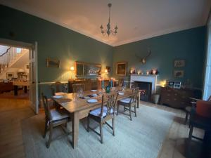a dining room with a table and chairs and a fireplace at Chillingham Manor in Chillingham