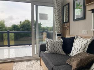 a living room with a couch and a sliding glass door at Chapel Fields Holiday Park in Chapel Saint Leonards