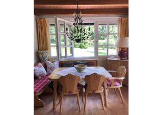 une salle à manger avec une table, des chaises et un lustre dans l'établissement Landhaus Finest Haus Weickenhof, à Velburg