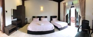 A bed or beds in a room at Singgahsana Villa