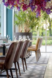 uma sala de jantar com mesa, cadeiras e flores em Holiday Inn Hotel Brussels Airport, an IHG Hotel em Diegem