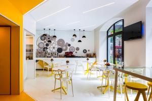 a dining room with yellow chairs and tables at VISIONAPARTMENTS Geneva Mont-Blanc in Geneva