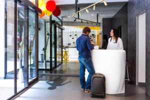 a man and a woman standing at a counter at VISIONAPARTMENTS Geneva Mont-Blanc in Geneva