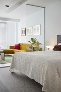 una camera con un grande letto e un divano giallo di Satori Suites a San Sebastián