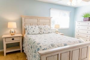 ein Schlafzimmer mit einem Bett, einer Kommode und einem Fenster in der Unterkunft Wild Dunes Resort - Vacation Rentals in Isle of Palms