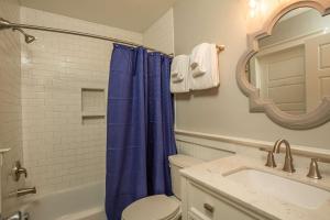 a bathroom with a blue shower curtain and a toilet at Wild Dunes Resort - Vacation Rentals in Isle of Palms