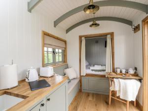uma cozinha com um balcão, um lavatório e um espelho em Jasmine Hut, Myrtle Farm em Bristol