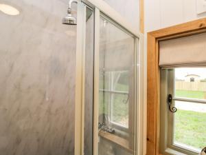 uma cabina de duche em vidro numa casa de banho com uma janela em Jasmine Hut, Myrtle Farm em Bristol