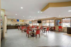 a restaurant with tables and chairs and a kitchen at Comfort Suites Fultondale I-65 near I-22 in Fultondale