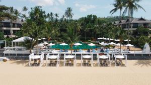 a beach with chairs and umbrellas on the beach at Anantara Bophut Koh Samui Resort in Bophut