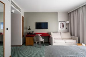 ヴロツワフにあるRentPlanet - Apartamenty Centrumのベッド、ソファ、デスクが備わるホテルルームです。