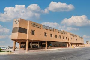un edificio con un reloj al costado. en Aram Hotel - AlMeshael Exit 18, en Riad