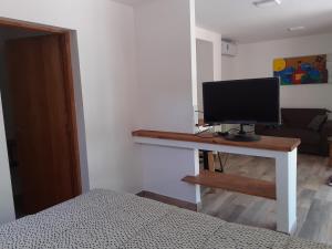 a bedroom with a desk with a computer monitor on it at Pequeña casa en chacras de coria in Chacras de Coria