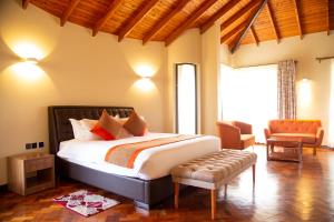 a bedroom with a large bed and a chair at Elmer Resort & Spa Naivasha in Naivasha