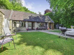 a house with a grill and chairs in the yard at The Stables, Batheaston in Batheaston