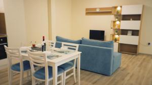 sala de estar con mesa y sofá azul en PAPAYA APARTMENTS, en Varna