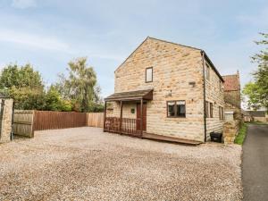 an old stone house with a fence and a driveway at Grange View in Ripon