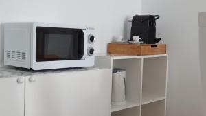 a microwave sitting on top of a white cabinet at Palmeira Comfort in Aveiro