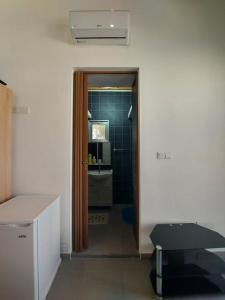 a room with a bathroom with a sink and a doorway at Anna Guesthouse 10 min walk from the beach in Larnaka