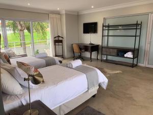 - une chambre avec 2 lits, un bureau et une télévision dans l'établissement The Studio on Cordia DSTV WIFI 2km from Umhlanga Beach, à Durban