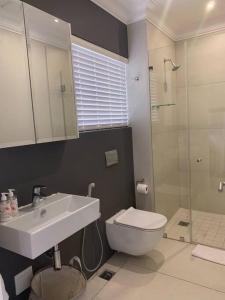 a bathroom with a sink and a toilet and a shower at The Studio on Cordia DSTV WIFI 2km from Umhlanga Beach in Durban