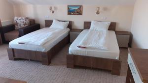a bedroom with two beds and a couch at Vila Teju Valeni in Vălenii de Munte