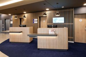 a lobby with two reception desks and a tv at Holiday Inn Express - Lustenau in Lustenau