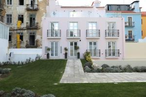a white building with a lawn in front of it at TM Luxury Apartments Lisbon in Lisbon