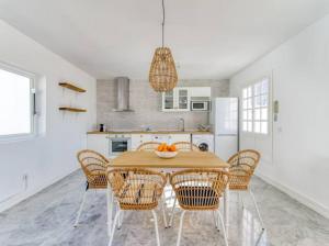 eine Küche mit einem Holztisch mit Stühlen und einem Esszimmer in der Unterkunft The Patio House Comfort and Style at Pasito Blanco in Pasito Blanco