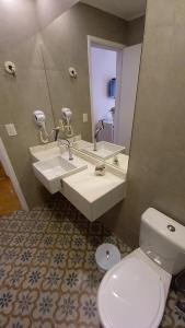 a bathroom with two sinks and a toilet and a mirror at Pousada Solar da Imperatriz in Tiradentes