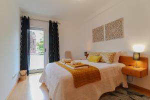 una camera con un grande letto e una finestra di Janela Mar Golden a Lagoa